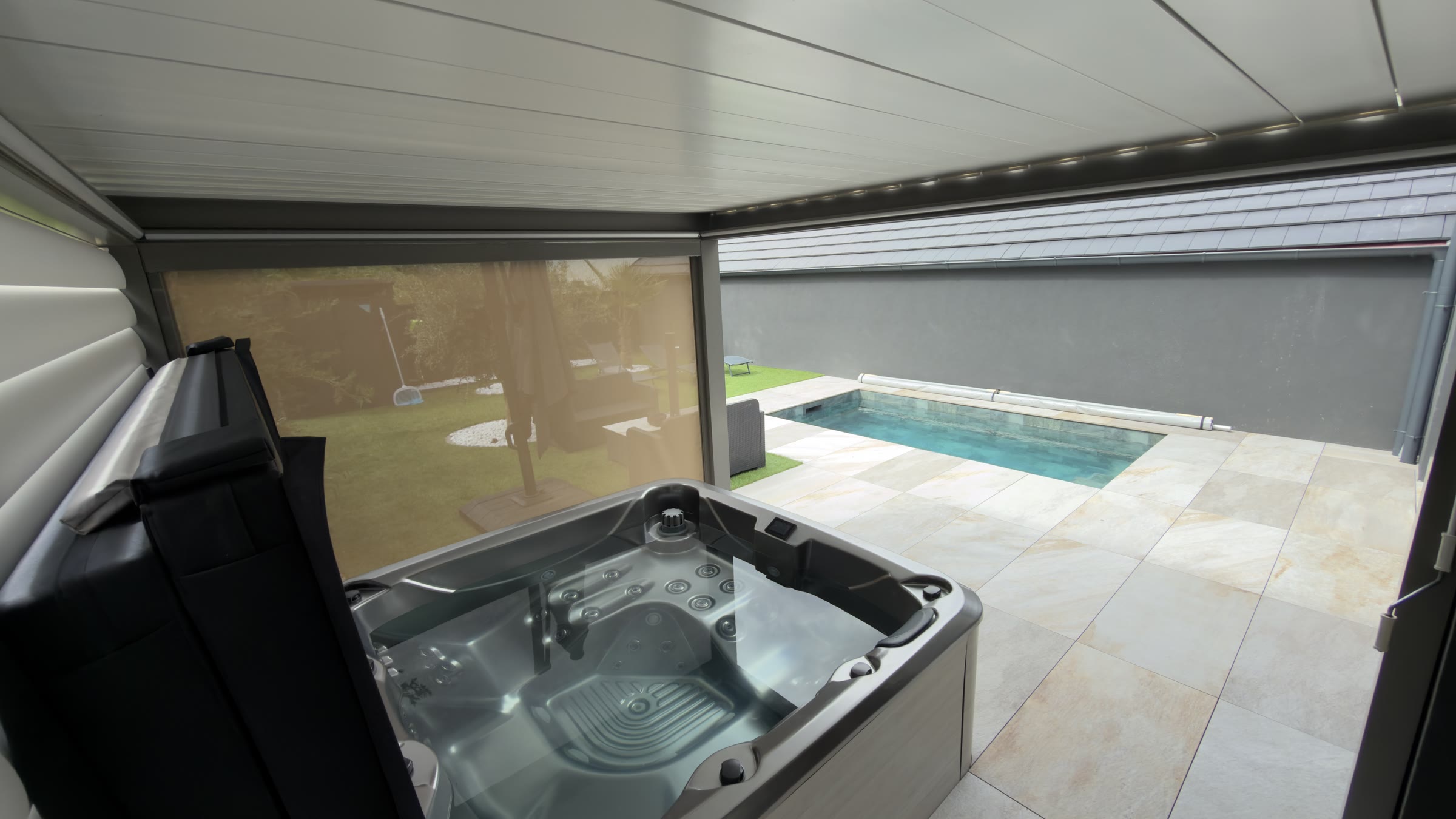 Le jacuzzi sous abri, face à la piscine